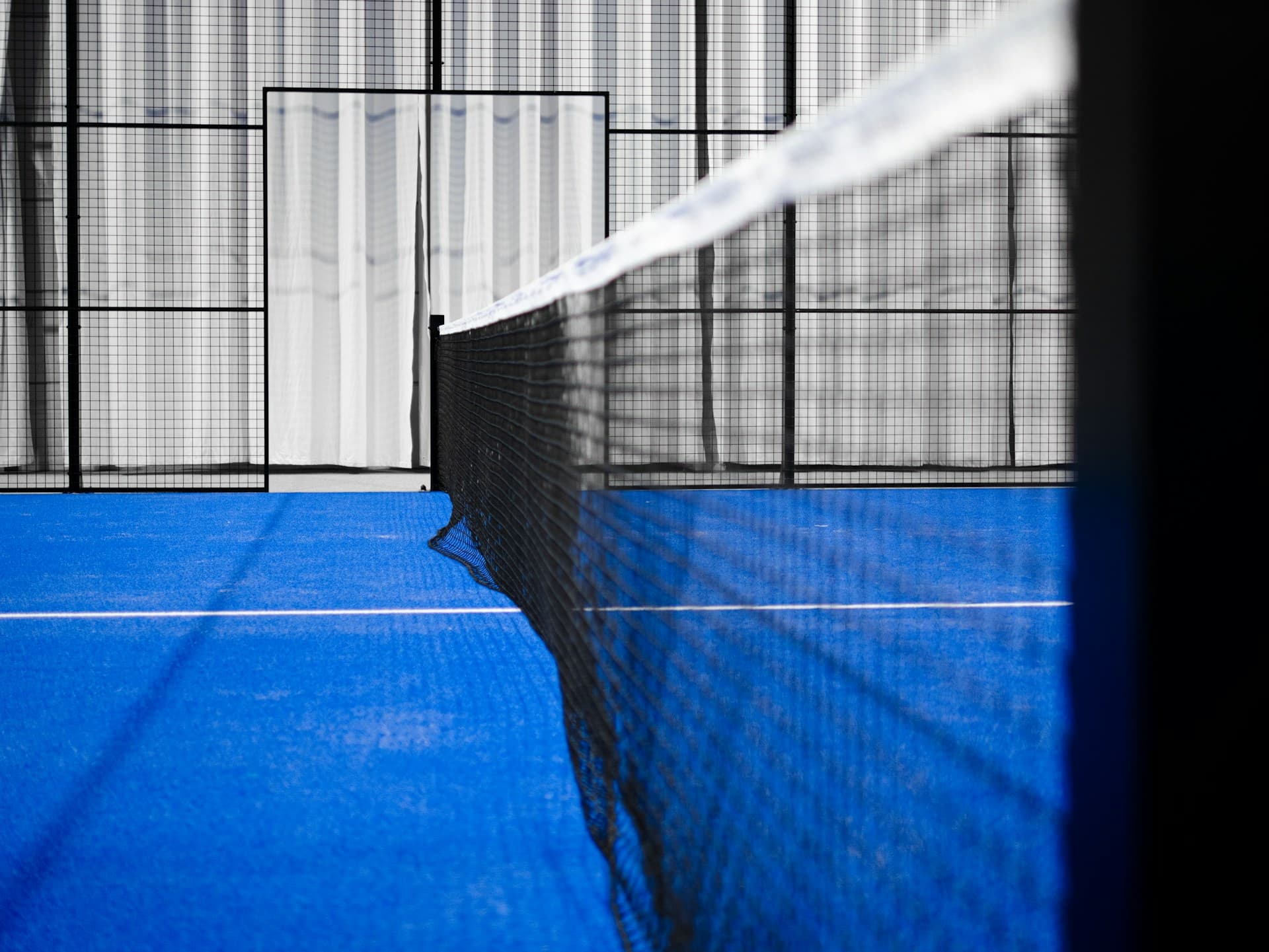 Campo da padel con rete e superficie blu